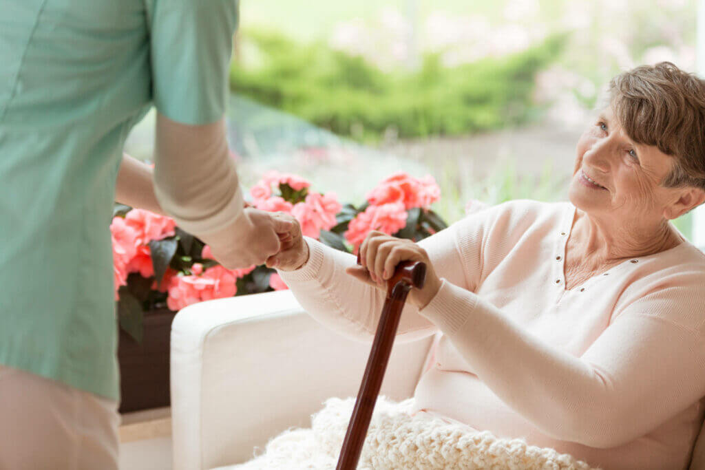 Therapist helping an older adult stand safely