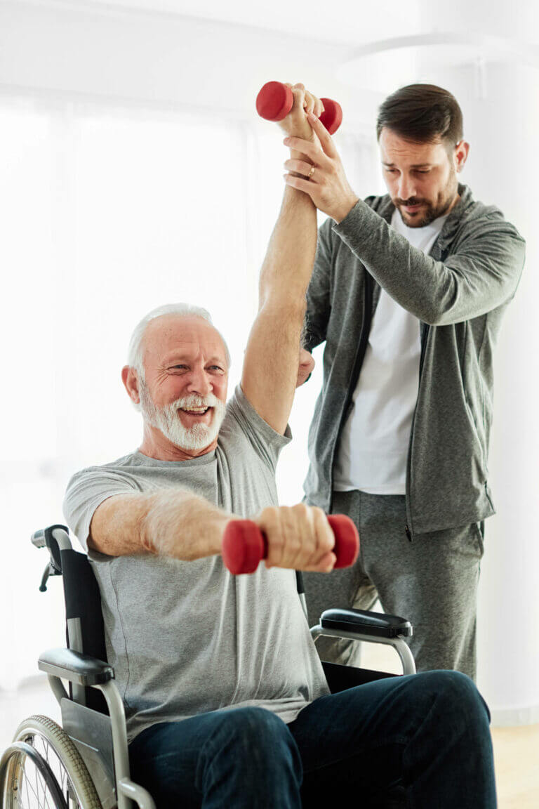 Older adult exercising with a resistance band and therapist